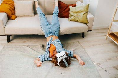 Low section of woman sitting on bed at home