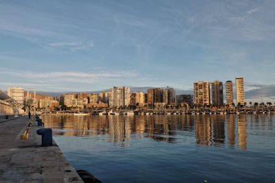 Buildings by sea against sky