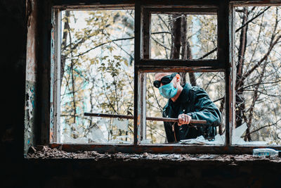 Rear view of man standing by window