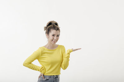 Portrait of smiling woman standing against white background
