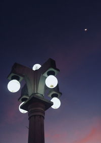 Low angle view of illuminated street light against sky