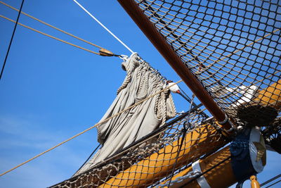 Low angle view of sailboat against blue sky