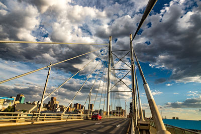 Road by bridge against sky in city