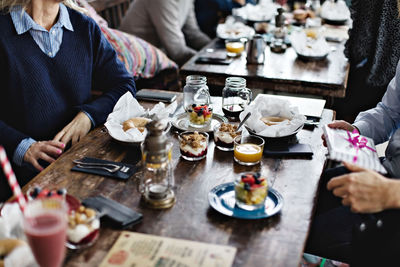 Midsection of couple eating brunch at dining table in restaurant