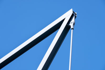 Low angle view of metal structure against blue sky