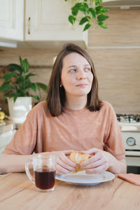 Portrait of smiling woman sitting on table