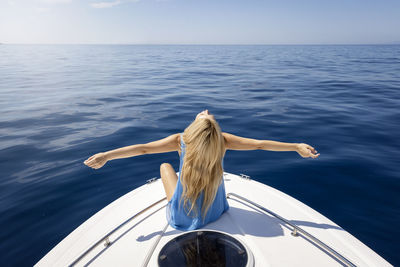 Rear view of woman in sea against sky