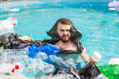 Portrait of young man swimming in pool