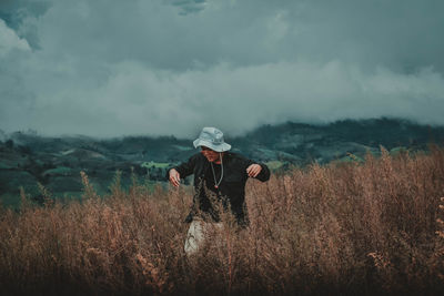 Man standing on field against sky