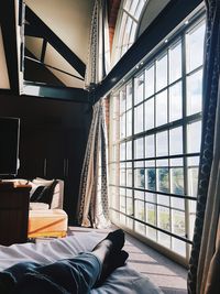 Low section of person relaxing on bed at home