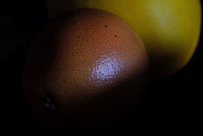 Close-up of orange slice over black background