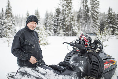 Portrait of retirement aged man snowmobiling durign winter.