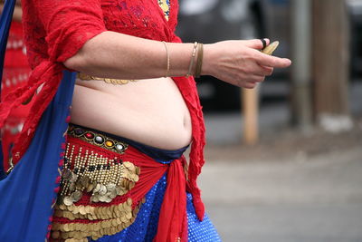 Midsection of young woman standing outdoors