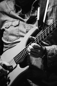 Midsection of man playing guitar