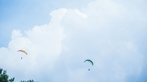 Low angle view of person paragliding against sky