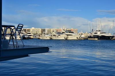 Sailboats moored in sea against blue sky