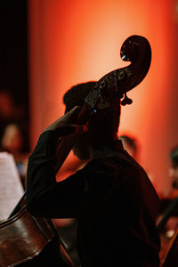 Man playing cello at music concert