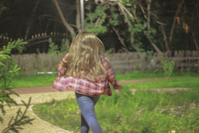 Rear view of woman standing by tree