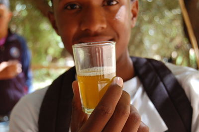 Close-up portrait of man holding drinking glass