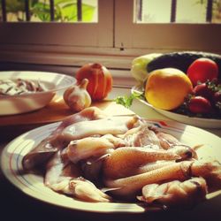 Close-up of squid in plate with fruits on table