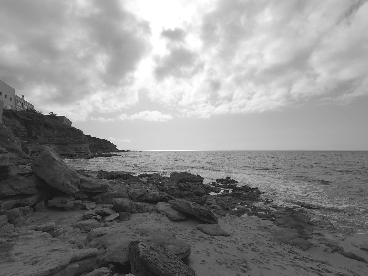 SCENIC VIEW OF ROCKY BEACH AGAINST SKY