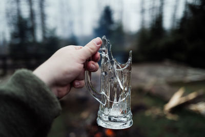 Close-up of hand holding glass bottle