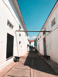 Street amidst buildings against blue sky