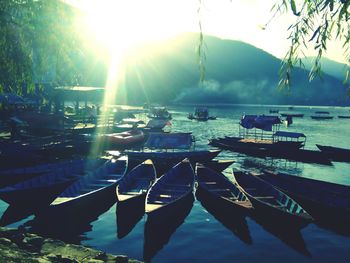 Boats moored in water against sky