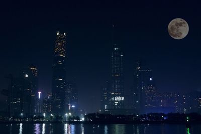 Illuminated cityscape against sky at night