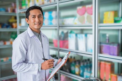 Portrait of young man standing in supermarket