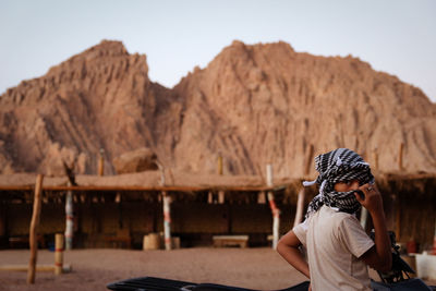 Rear view of woman sitting on mountain