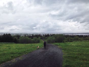 Scenic view of grassy field against cloudy sky