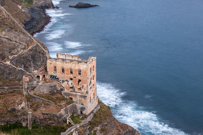 Long exposure of the roofless ruin of  casa hamilton on top of lonely cliff above the sea.