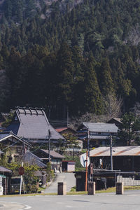 Houses by trees and buildings against sky