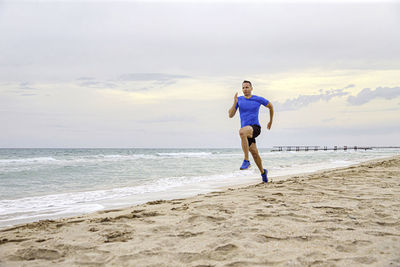 Full length of boy on beach against sky