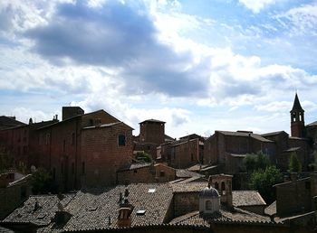 Houses in town against cloudy sky