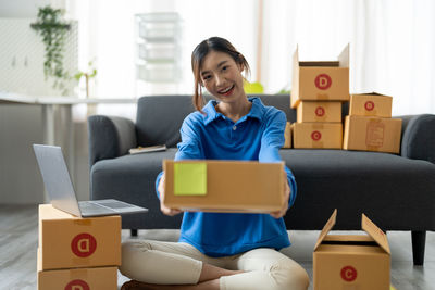 Young woman using mobile phone while sitting at home