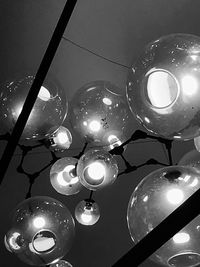 Low angle view of illuminated pendant lights hanging from ceiling