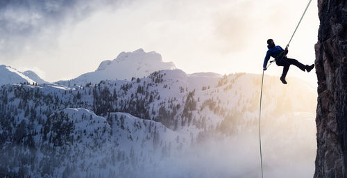 Man skiing on mountain range against sky