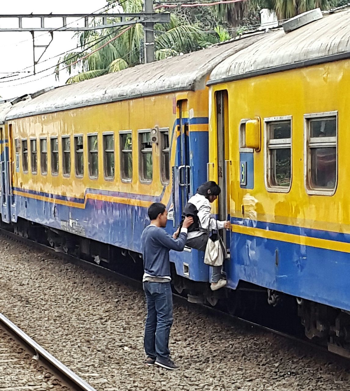 men, transportation, rail transportation, lifestyles, railroad track, public transportation, mode of transport, train - vehicle, leisure activity, full length, passenger train, casual clothing, travel, railroad station platform, rear view, architecture, person