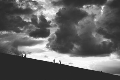 Silhouette of people against dramatic sky