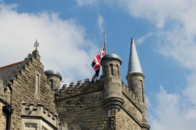 Low angle view of flags on building against sky