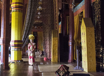 Woman with traditional clothing standing in corridor