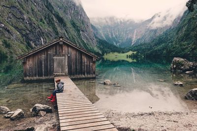 Woman standing by lake against mountains