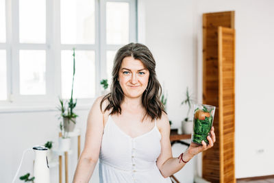 Portrait of smiling woman holding drinking glass