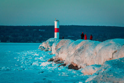 Tourists braving the ice to reach the light house in petoskey michigan