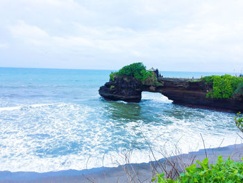 Scenic view of rocks in sea against sky