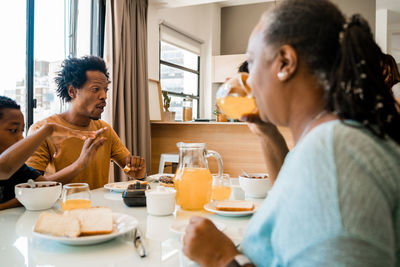 Family eating breakfast in kitchen at home