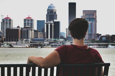 Man and cityscape against sky