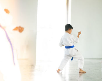 Rear view of boy looking at camera at home